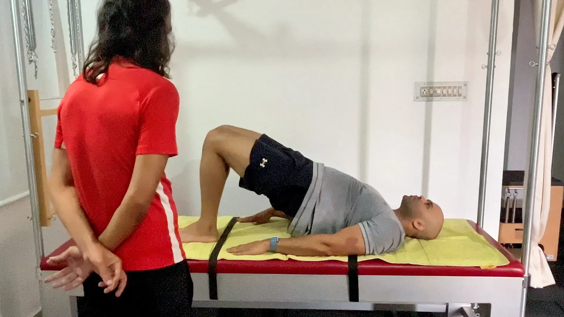 Pilates instructor observing a client at the start of a private session in Bengaluru